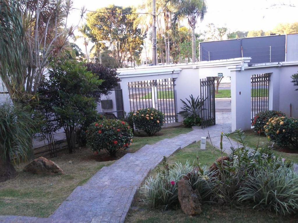Entrada com jardim florido e portão de acesso